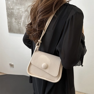 Chic beige lychee grain saddle bag for women with flap and round button detail