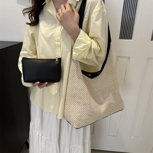 Chic woven beach tote with black trim and matching small cosmetic pouch for summer