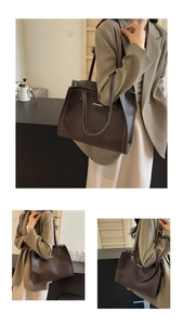 Detail of dark brown leather tote bag with white contrast stitching and gold logo