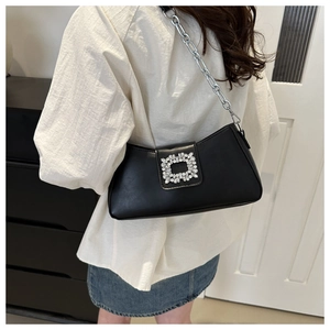 Model view of black leather baguette bag with crystal buckle and silver chain strap