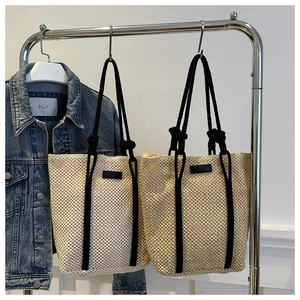 Detail of hollow woven mesh tote bags with black rope handles and minimalist leather patch