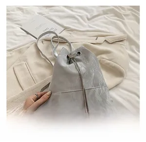 Detail of silver bucket bag with pleated texture, drawstring closure and butterfly buckle