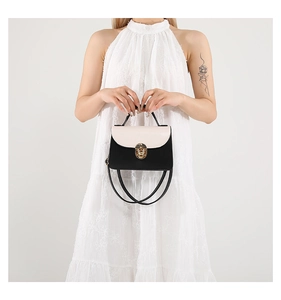 Detail of minimalist black and white shoulder bag with golden round ring buckle clasp