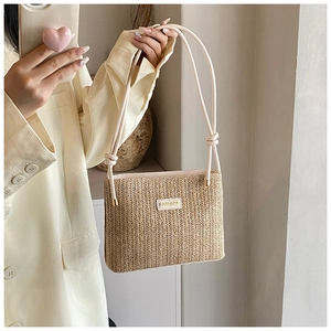 Detail of hand-woven straw bucket bag with fashion leather tag and cotton cord handle