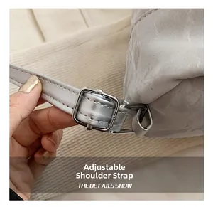Detail showing adjustable faux leather shoulder strap with a silver square metal buckle