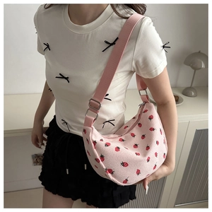 Pink corduroy crescent bag featuring strawberry prints and adjustable shoulder strap