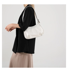 Chic white PU leather underarm bag for women shown worn on the shoulder over a black blazer