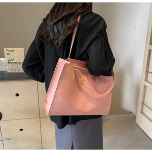Détail du grand sac cabas rose avec logo doré et finitions de couture soignées
