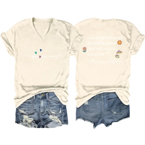 Detail of V-neck white T-shirt with you are enough print and distressed denim shorts