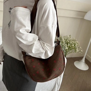 Brown strawberry print corduroy crescent shoulder bag with adjustable strap in casual interior