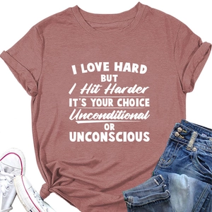 Détail du t-shirt rose poudré avec slogan blanc, porté avec un jean et des baskets