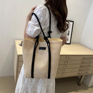 Large cream woven straw tote bag with black rope straps for summer beach holidays