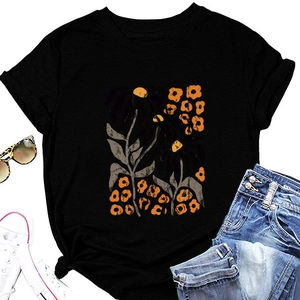 Flat lay of black round neck T-shirt with vintage yellow floral leaf print and accessories