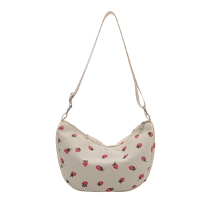Corduroy hobo bag with strawberry print and adjustable strap on a white background