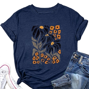 Detail view of navy t-shirt featuring artistic yellow and orange floral print with denim jeans