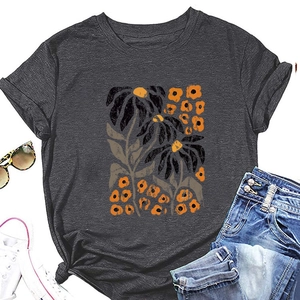 Flat lay of a grey floral t-shirt with orange leaves, styled with jeans and sneakers