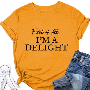 Flat lay of an orange cotton T-shirt with 'First of All' text and denim shorts outfit