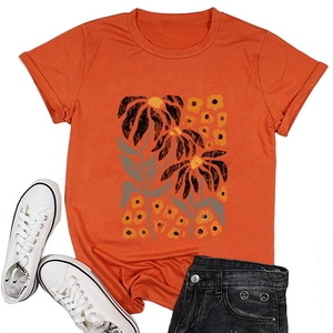 Flat lay of orange crew neck T-shirt with yellow floral print and denim shorts