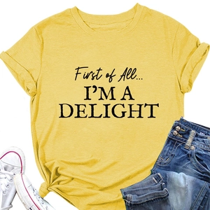 Flat lay of yellow cotton T-shirt with 'I'M A DELIGHT' slogan, denim shorts and sneakers