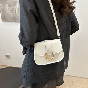 White leather crossbody bag with golden U-shaped buckle and adjustable shoulder strap