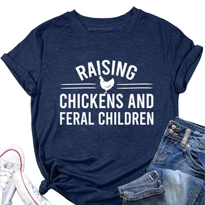 Flat lay of navy blue T-shirt featuring Raising Chickens and Feral Children text print