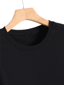 Detail of a casual black round neck tank top showing fabric texture on wooden hanger