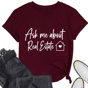 Dettaglio della t-shirt bordeaux con scritta 'Ask me about Real Estate' e grafica casa