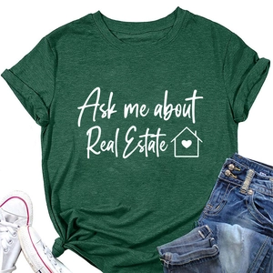 T-shirt verde 'Ask me about Real Estate' stesa con pantaloncini e scarpe bianche