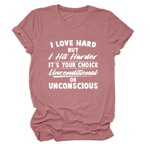 Détail des manches retroussées et de l'imprimé blanc sur le T-shirt en coton rose poudré
