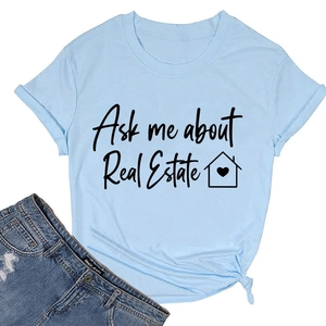 T-shirt azzurra stesa con slogan 'Ask me about Real Estate' e dettaglio nodo sul fondo