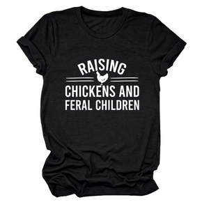 Close-up of screen-printed slogan Raising Chickens and Feral Children on black cotton T-shirt