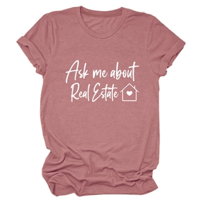 Dettaglio macro della stampa 'Ask me about Real Estate' su t-shirt rosa a maniche corte