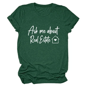 Dettaglio della stampa bianca 'Ask me about Real Estate' e icona casa su t-shirt verde