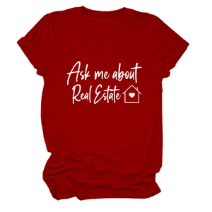 Dettaglio dello slogan immobiliare e icona casa cuore su t-shirt rosso scuro
