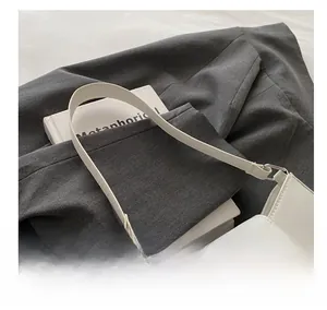 Détail du sac sous le bras blanc minimaliste avec une boucle en métal doré unique