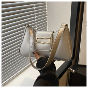 Detail of silver baguette bag with a matte metallic finish and gold rectangular buckle