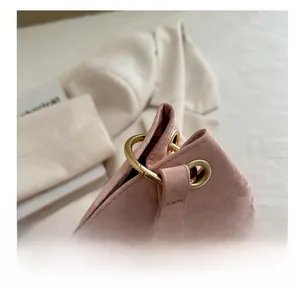 Detail of light pink pleated tote bag with gold metal rings and reinforced eyelets