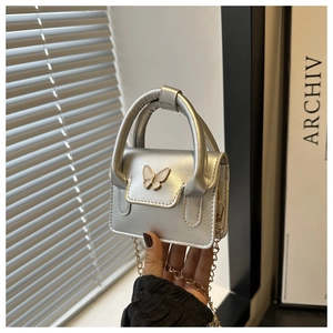 Detail of silver mini bag with 3D pink butterfly buckle and metallic chain strap