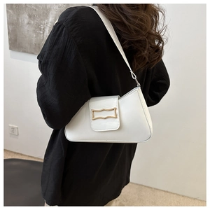 Détail d'un sac à bandoulière en cuir verni blanc avec boucle métallique dorée élégante