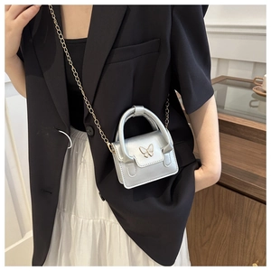 Silver mini crossbody bag with a white butterfly buckle shown with a chic outfit