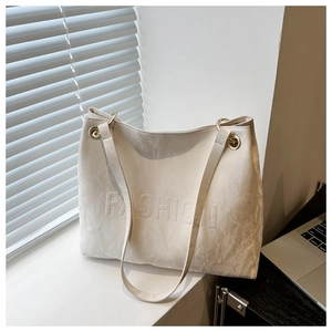 Detailed view of cream white tote bag with textured finish and embossed FASHION lettering