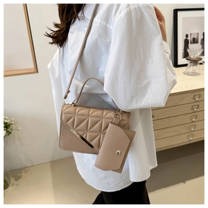 Detail of apricot quilted shoulder bag with golden hardware and matching card holder