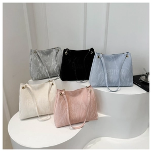 Close-up of pleated tote bags in five colors with embossed letters and gold rings