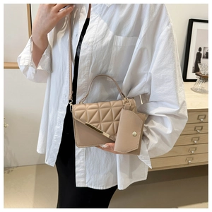 Quilted beige shoulder bag detail featuring elegant gold trim and a detachable mini pouch