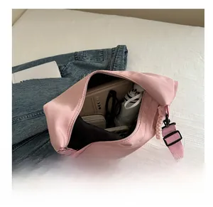 Internal storage capacity of the pink nylon tote showing umbrella, book, and glasses