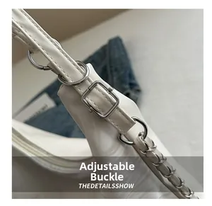 Detail of adjustable white leather strap with silver metal buckle and chain element