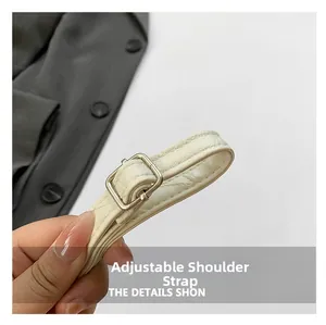 Detail of adjustable white lychee textured PU leather strap with silver metal buckle