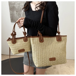 Detalle del conjunto de bolsos de paja con adornos de cuero marrón y asas anudadas