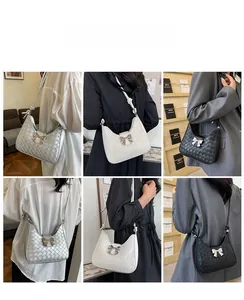 Three minimalist hobo shoulder bags in silver, cream, and black with bow hardware