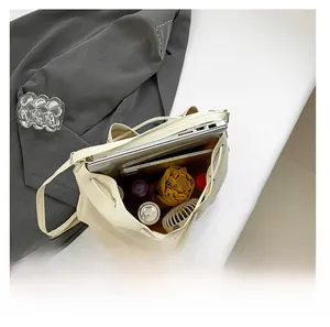 Spacious interior of beige tote bag holding a laptop, tablet, and daily essentials